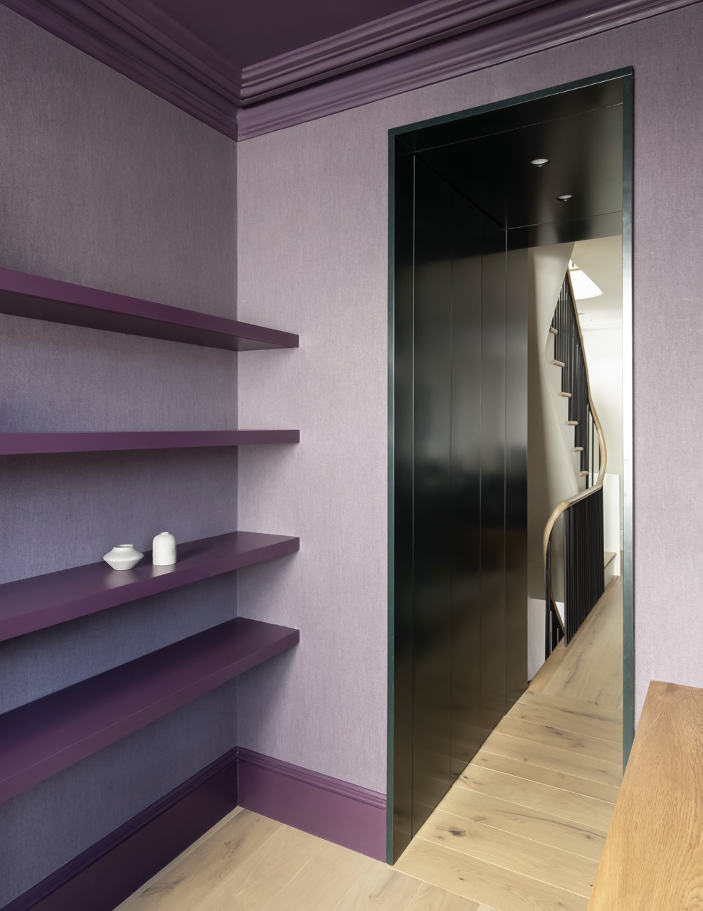 Jewel-toned study with custom plum shelving and brass details